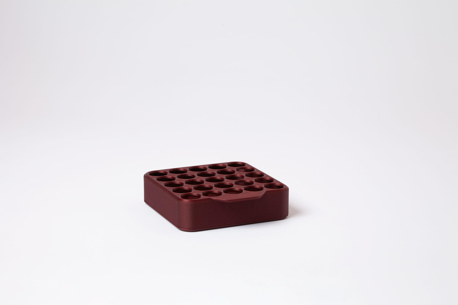 Compact grid display for 25 pre-roll tubes in deep red with faint flecks